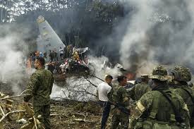Equipos de rescate en accidente de avión militar en Colombia con humo y restos en llamas.